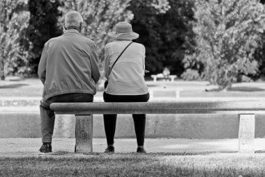 black and white old couple sitting on bench